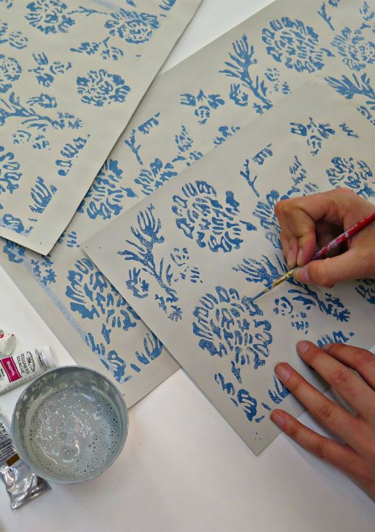 A close up of a GP & J Baker designer hand painting a design